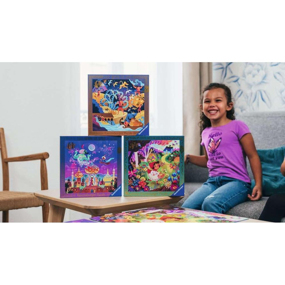 Una ragazza sorride su un divano con tre puzzle su un tavolo davanti.