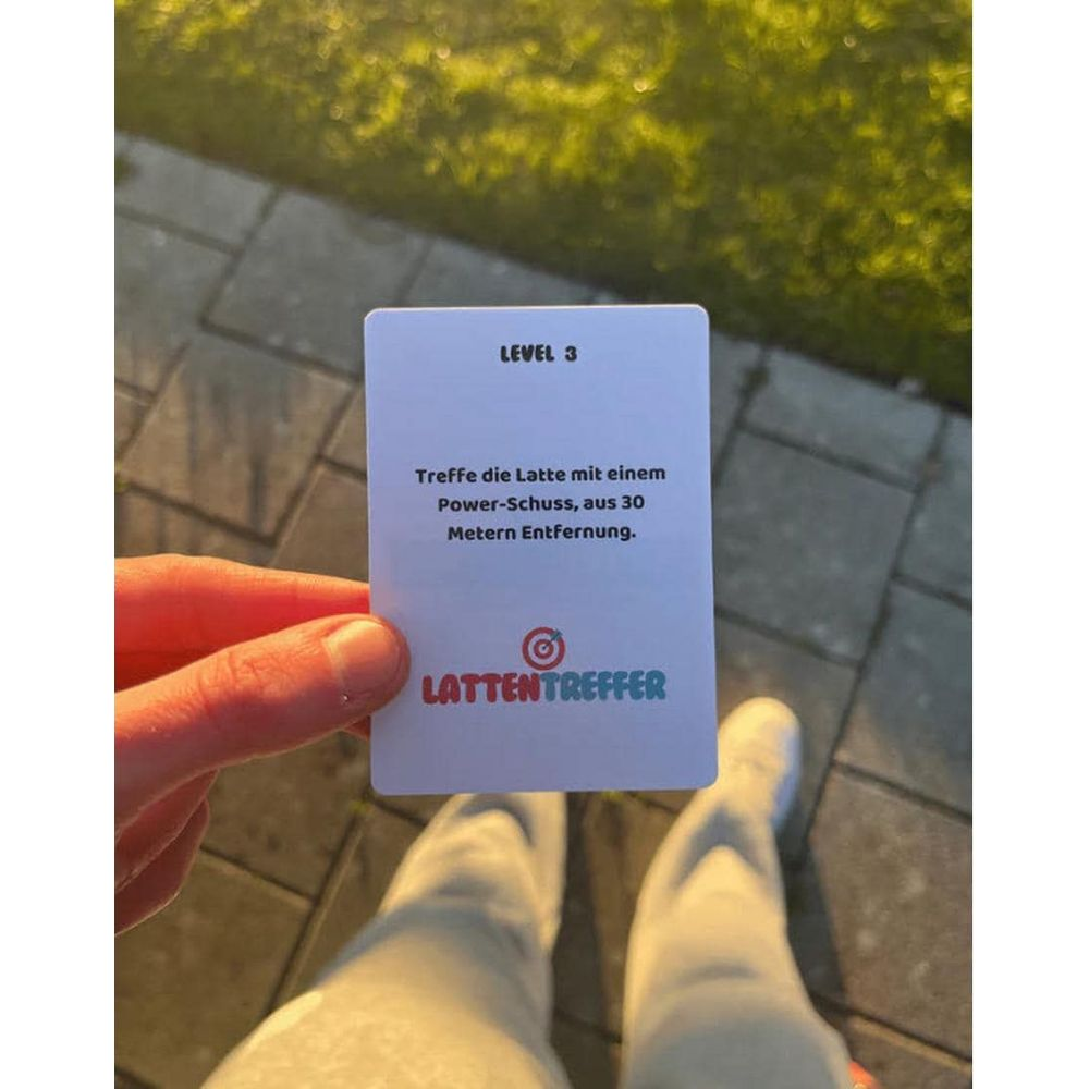 Una mano tiene una carta con 'LIVELLO 3' e istruzioni di gioco.