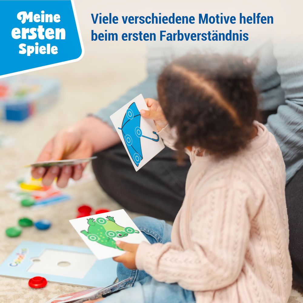 Un bambino tiene carte con una rana e un ombrello blu.