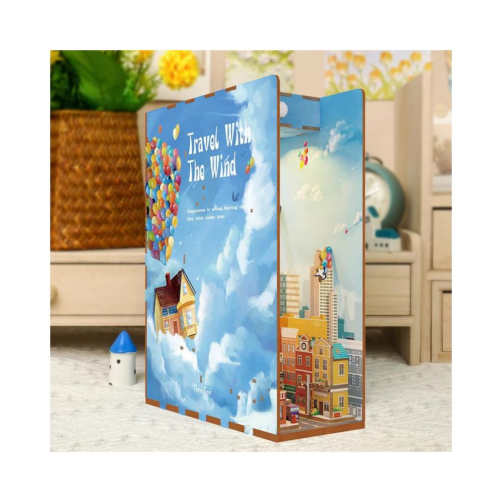 Ein 3D-Modell zeigt ein Haus, das von Ballons über einer Stadtlandschaft getragen wird. Text: 'Travel With The Wind'.