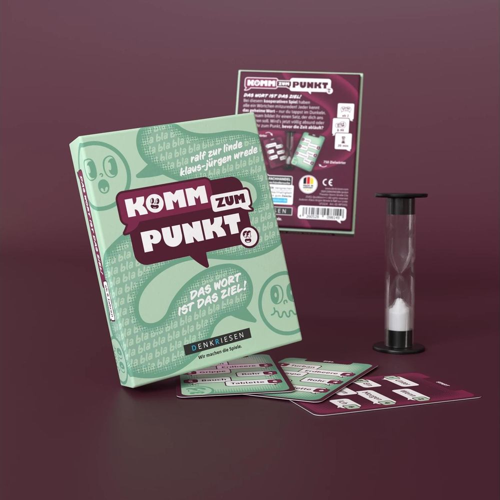 Jeu de société "Komm zum Punkt" avec sablier et cartes de jeu sur une table.