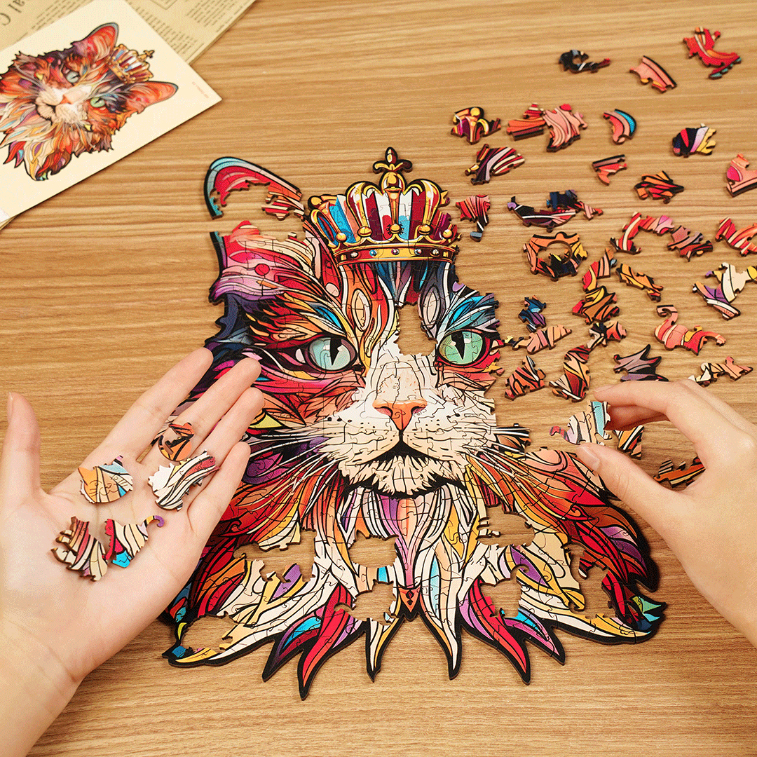 Bunte Katze-Puzzle auf dem Tisch, Hände legen Teile hinzu.