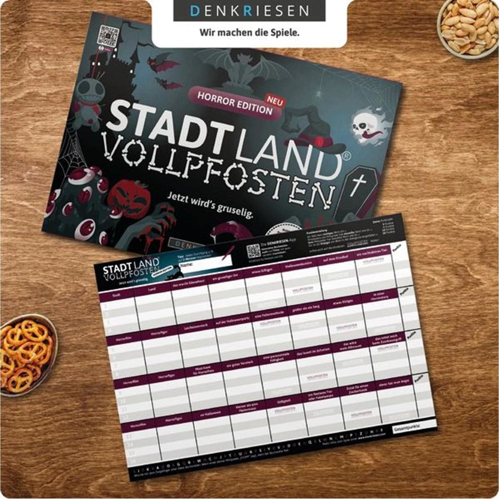 Spiel "Stadt Land Vollpfosten" Horror Edition auf einem Holztisch mit Snacks.
