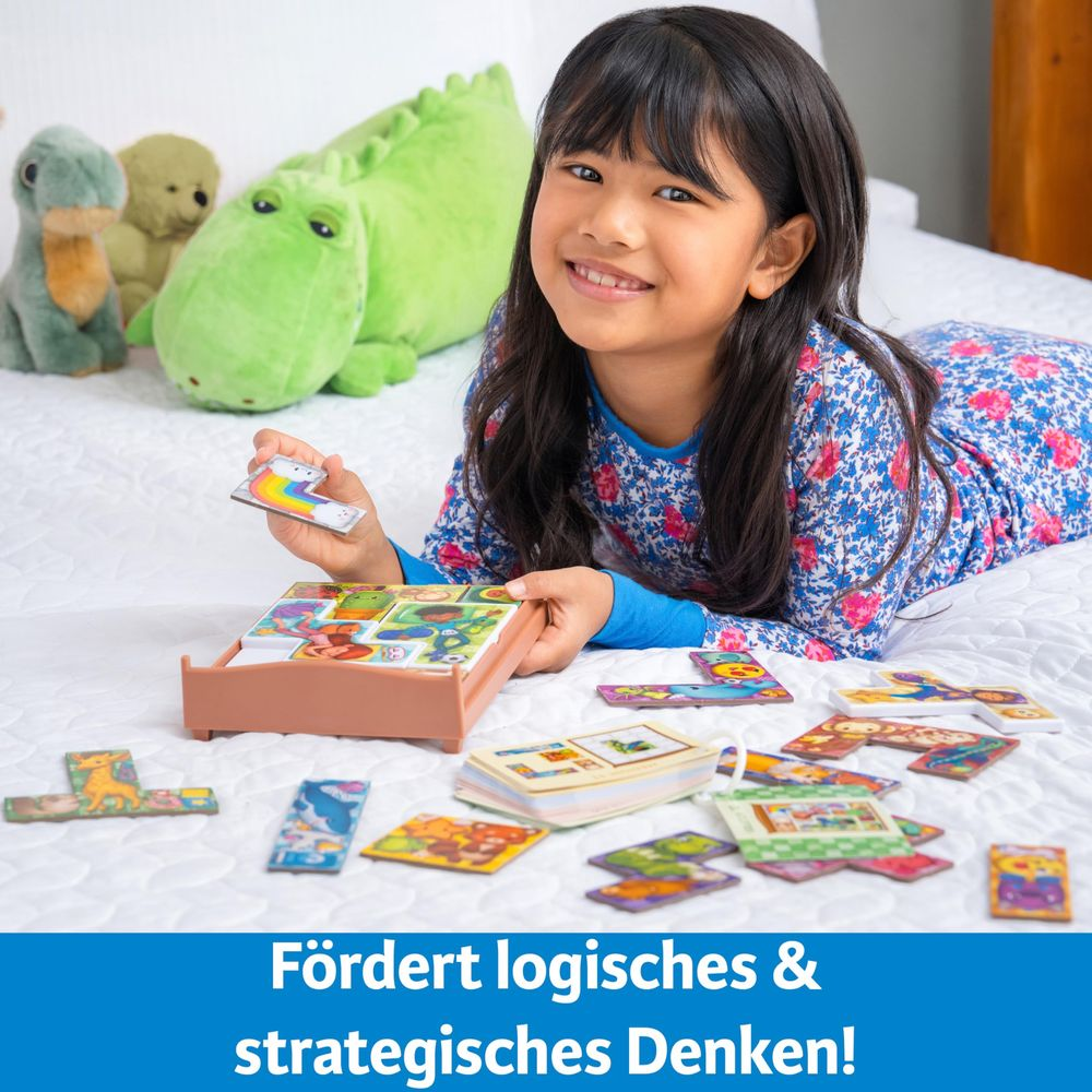 Ein Mädchen liegt auf einem Bett und spielt mit einem Puzzle. Im Hintergrund sind Stofftiere.
