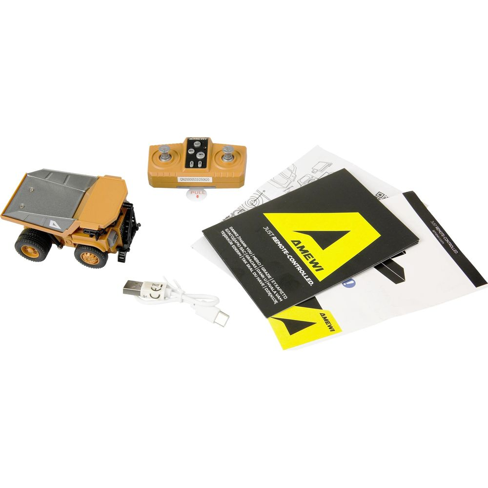Un camion jouet télécommandé jaune avec une manette, un câble USB et des instructions.