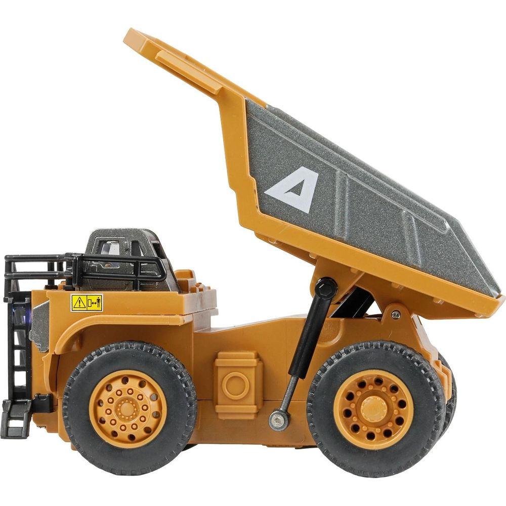 Un camion benne jouet jaune avec sa benne grise relevée, arborant un triangle blanc.