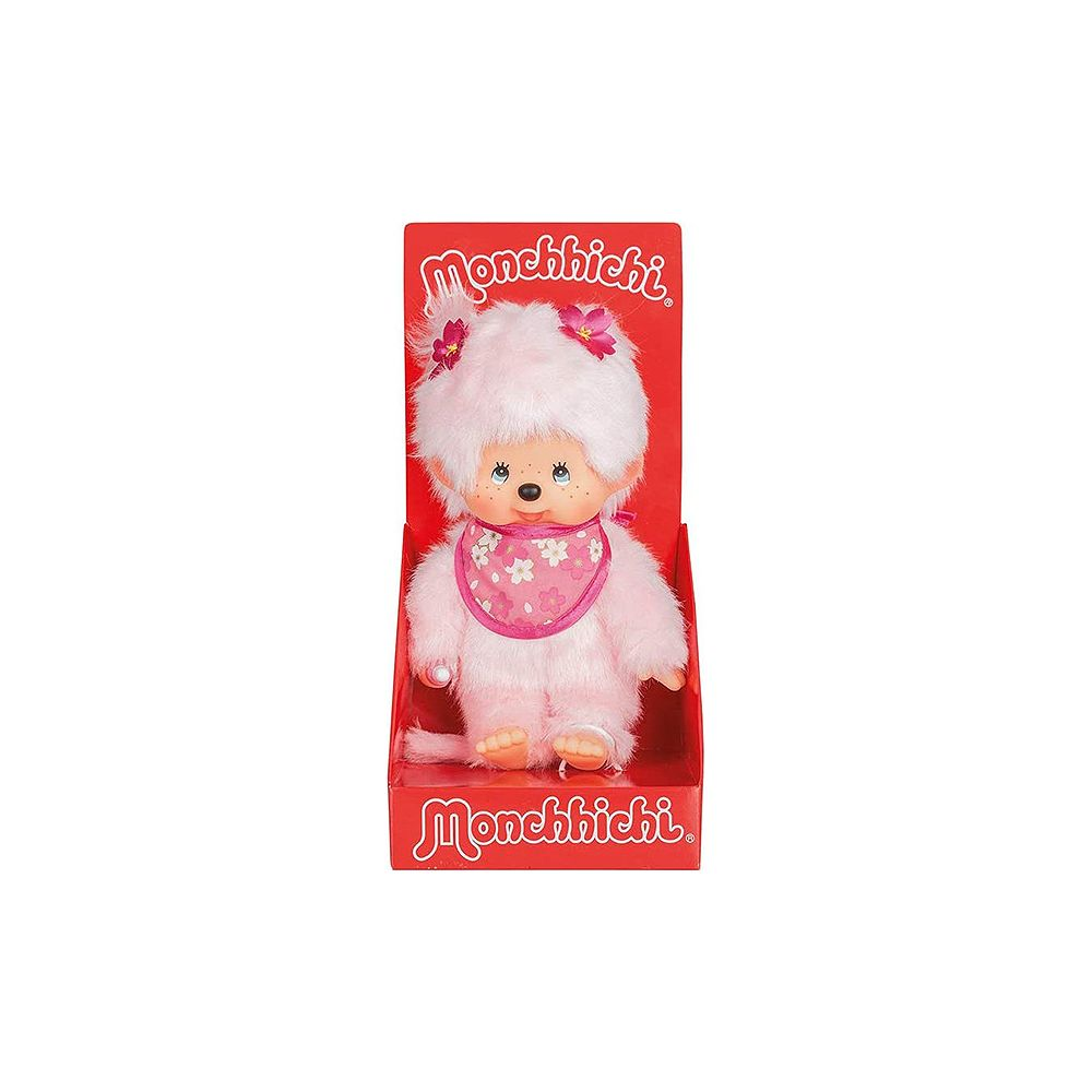Eine flauschige rosa Monchhichi-Puppe mit blumiger Latzhose in einer roten Displaybox.