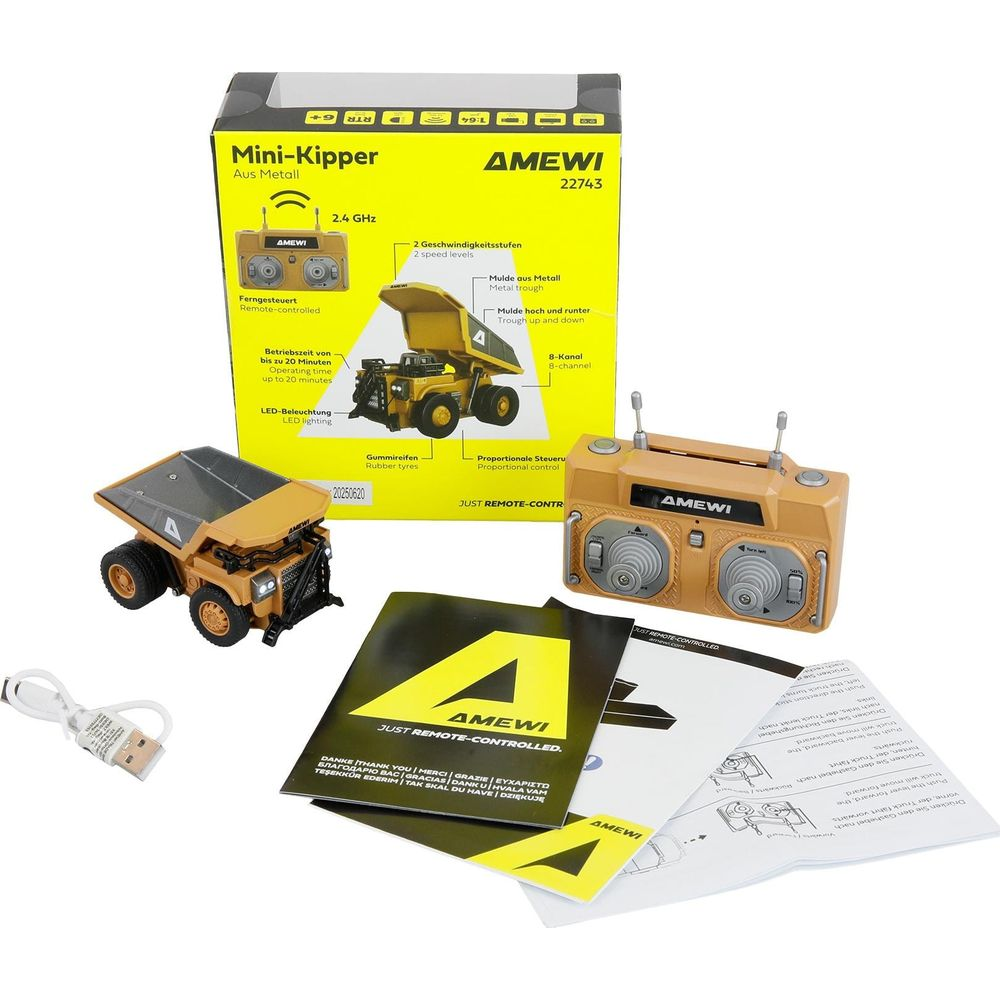 Un camion benne jaune télécommandé avec télécommande, câble et manuel.