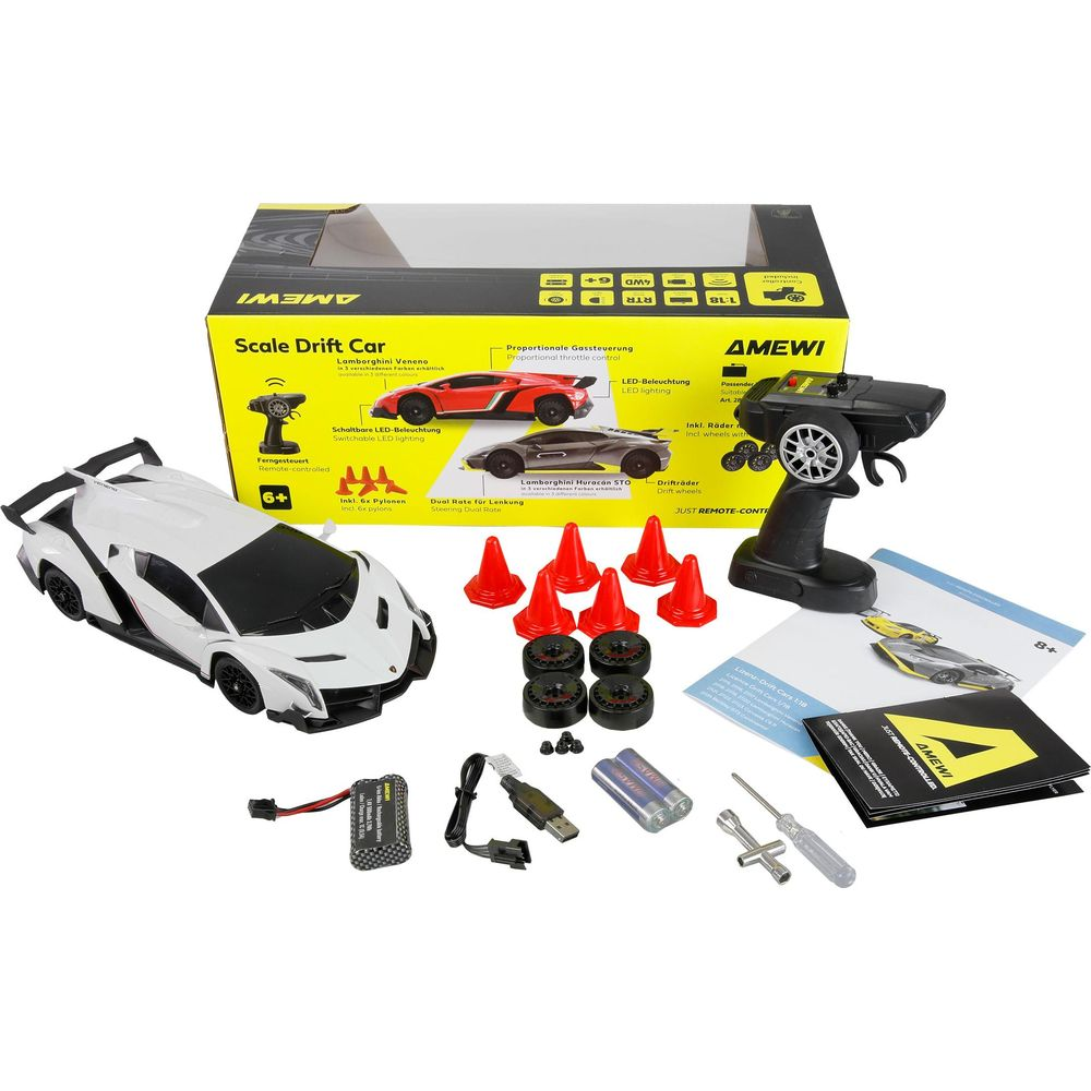 Un coche radiocontrol de drift blanco con mando, baterías, conos y herramientas.