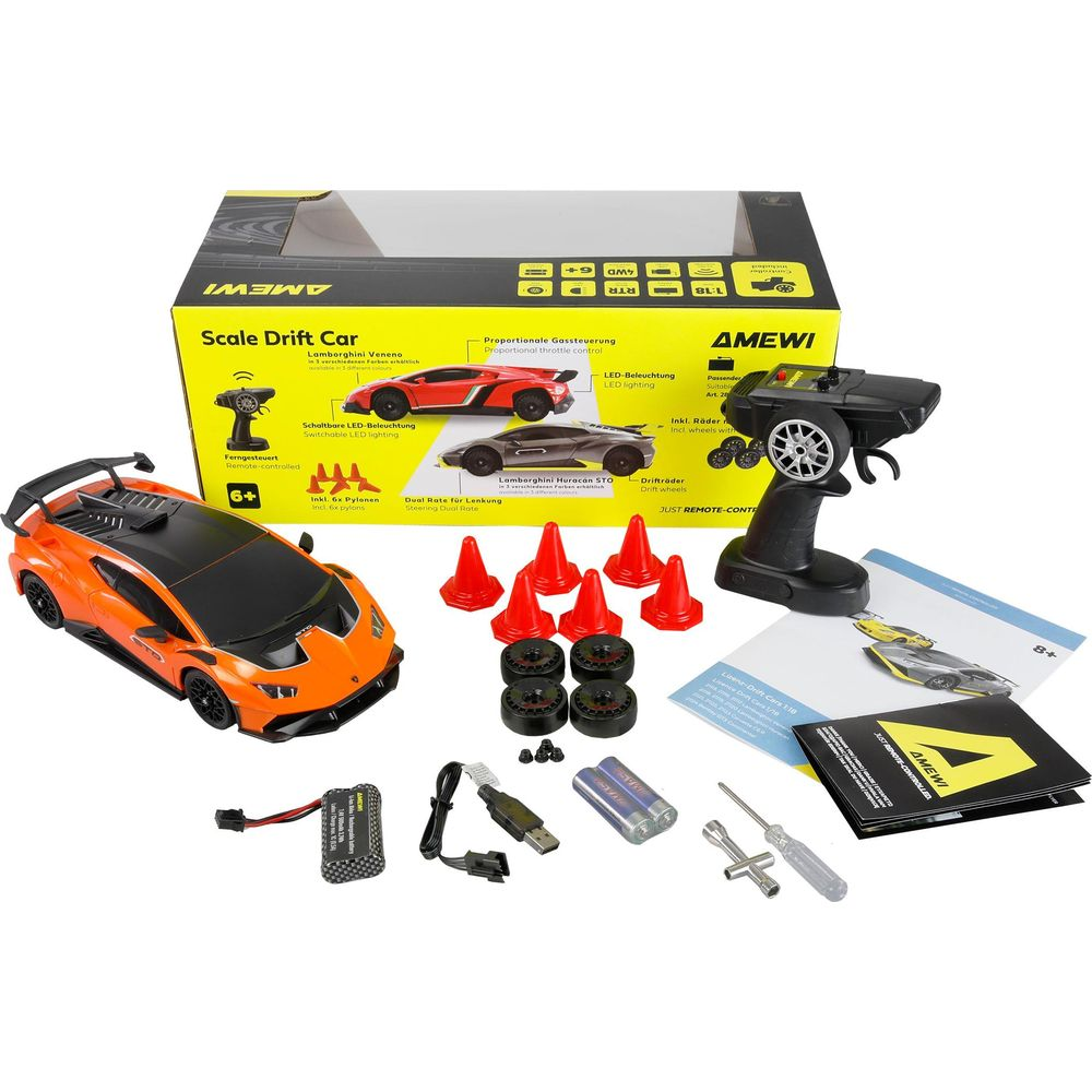 Un coche RC naranja de deriva con accesorios: mando, baterías, conos, ruedas, herramientas.
