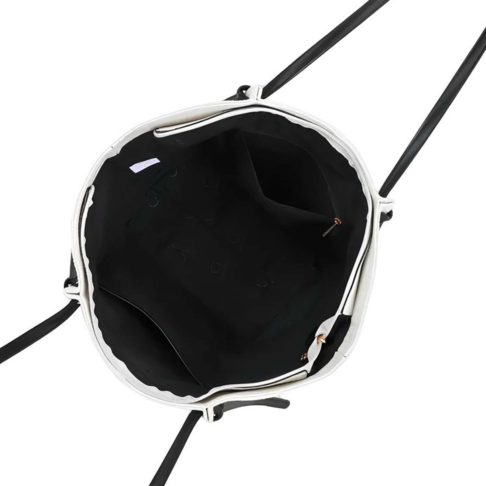 Un bolso tote blanco abierto con asas negras y interior negro.