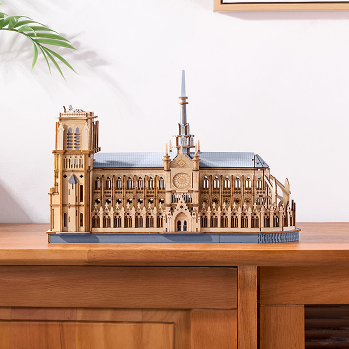 Maquette en bois de Notre-Dame avec des détails complexes, sur une table en bois.