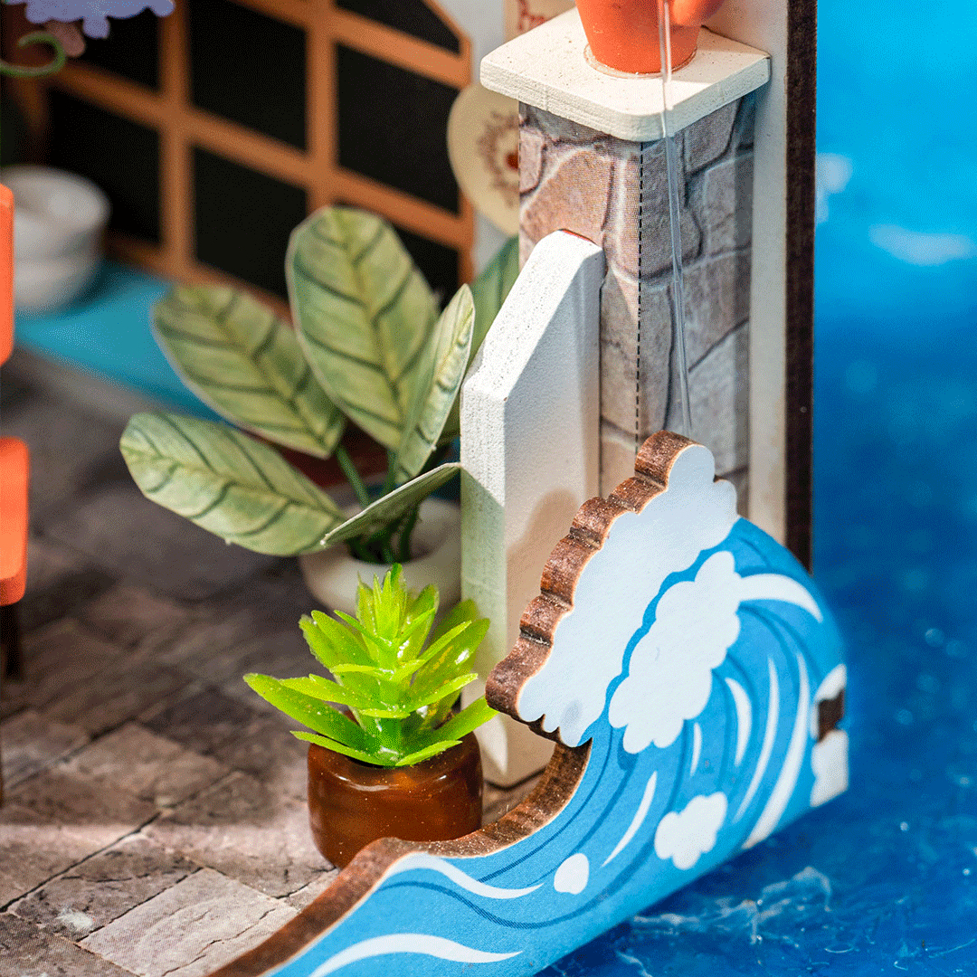 Scène miniature avec plantes, colonne en pierre et modèle de vague bleue.