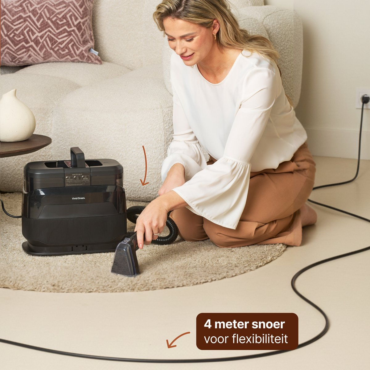 Femme nettoyant un tapis avec une machine, canapé et table à proximité.