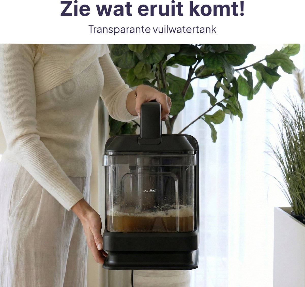 A woman holds a transparent container with brown liquid and foam.