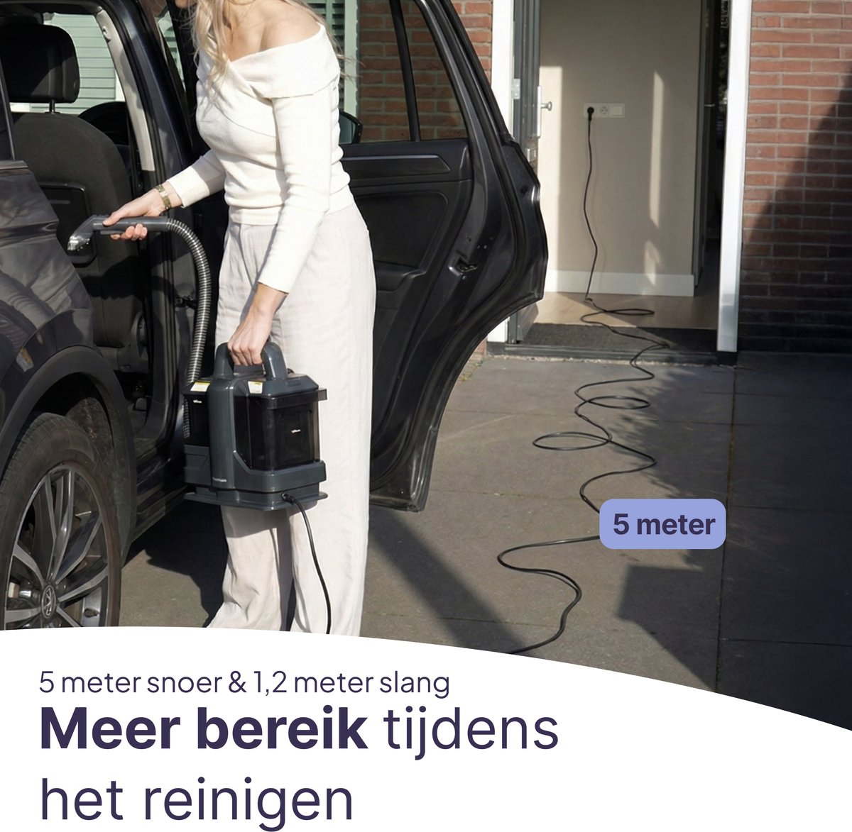 Woman cleans car interior with vacuum; 5m cord to house outlet.