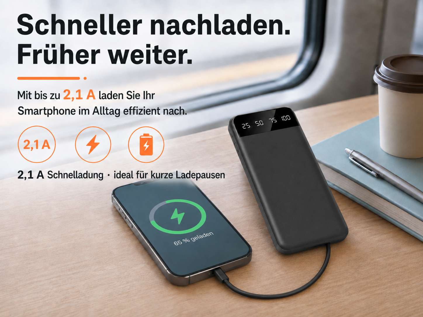 Ein schwarzes Smartphone und Powerbank laden auf einem Holztisch. Zugfenster im Hintergrund.