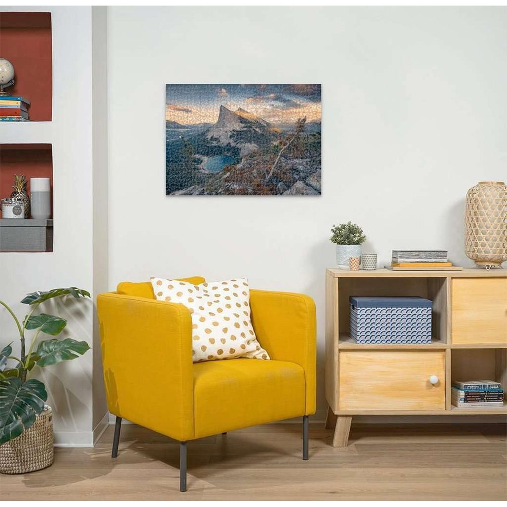 Un fauteuil jaune devant une armoire exposant un puzzle de montagne et de lac.