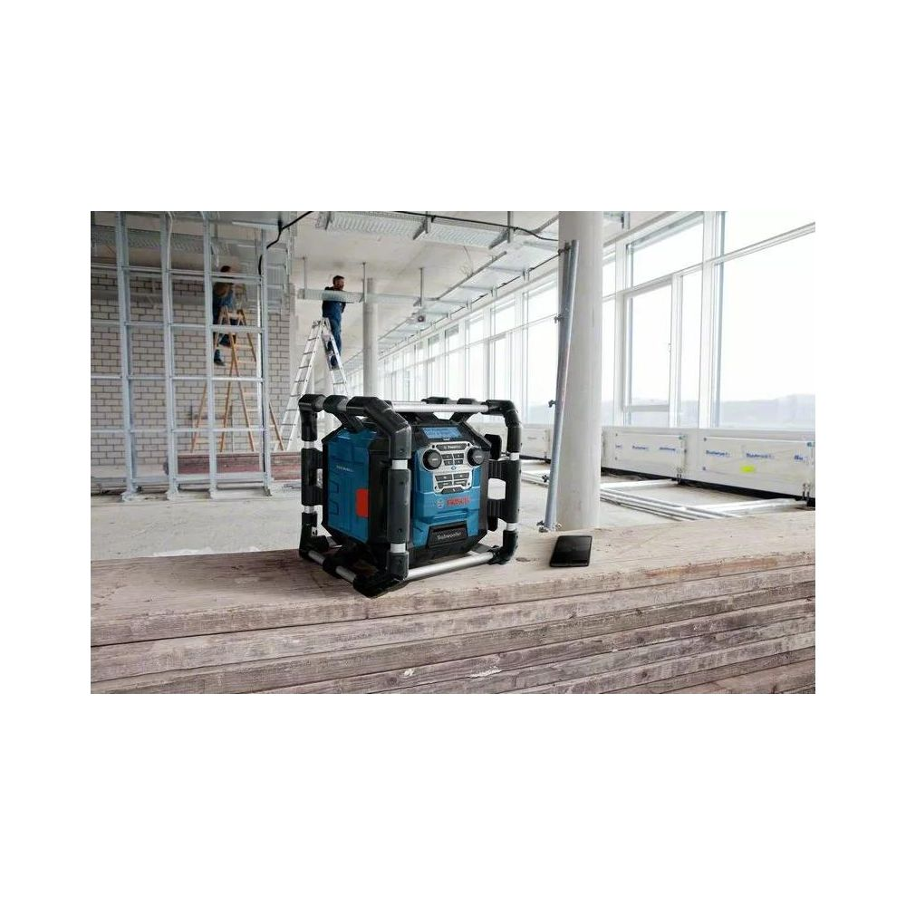 Une lampe de chantier bleue Bosch est posée sur des planches de bois sur un chantier.