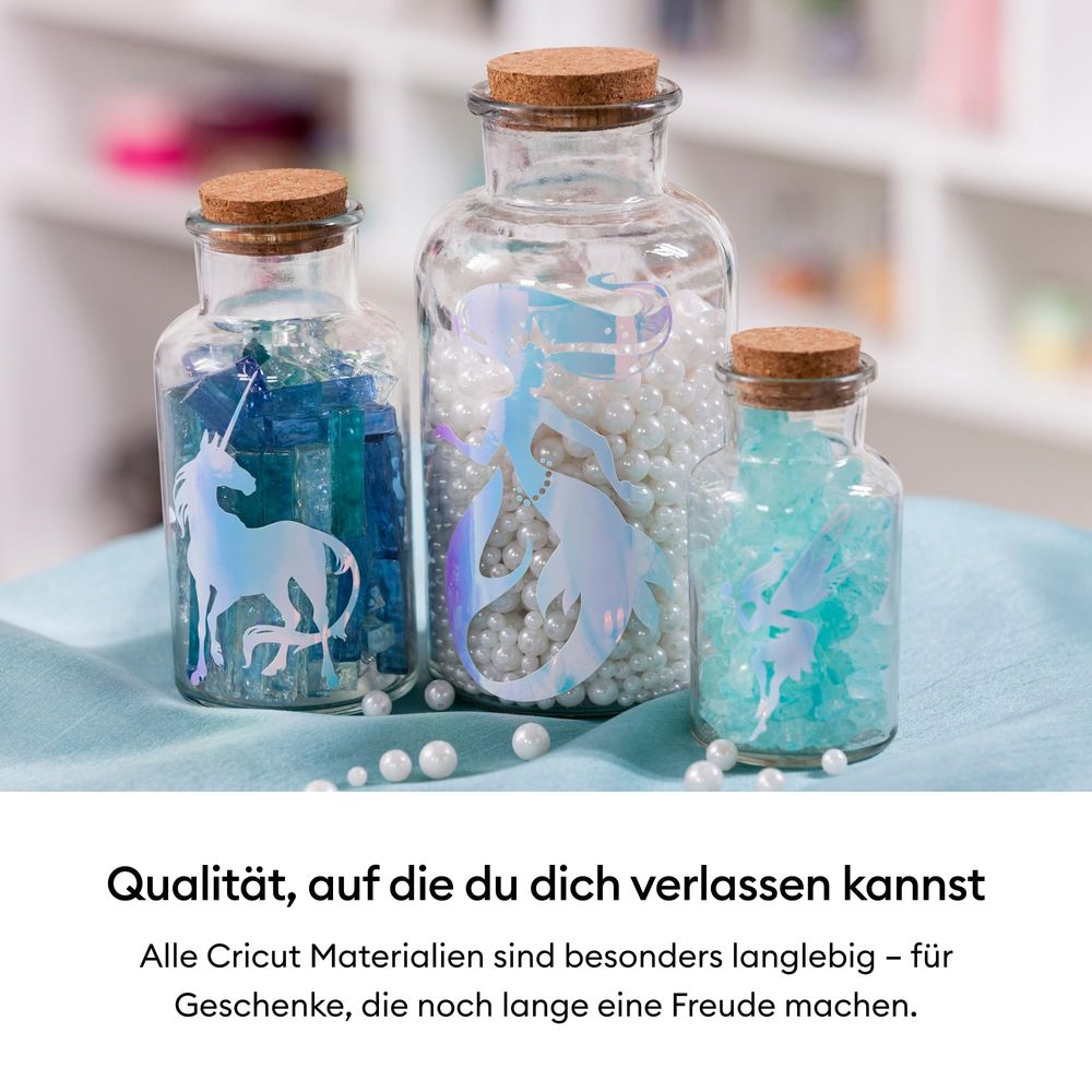 Drei Glasflaschen mit Korken, gefüllt mit Perlen und Dekorationen, zeigen Einhorn und Meerjungfrau.