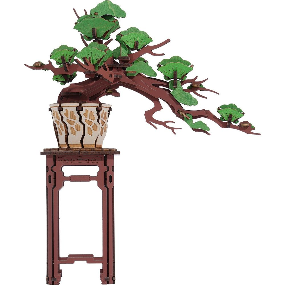 Un bonsaï modèle en bois avec des feuilles vertes dans un pot décoratif sur un support.