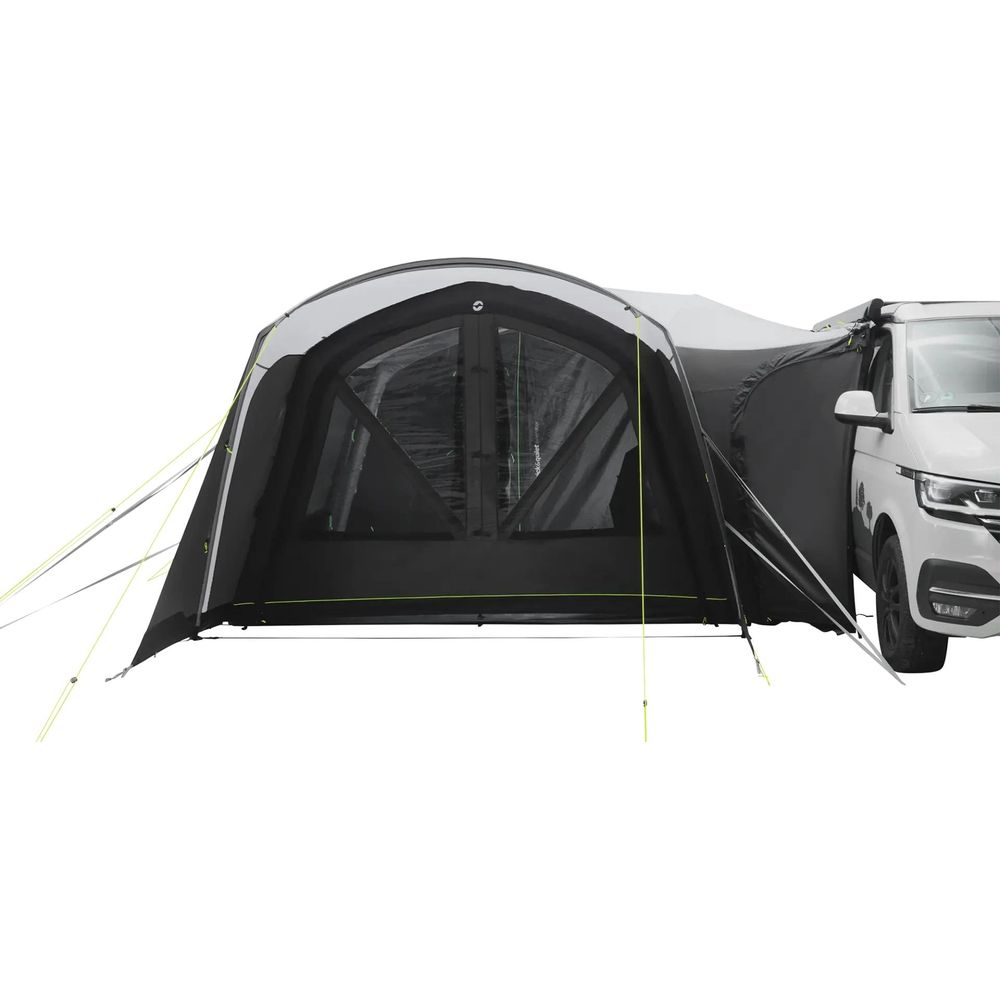 Una tenda da sole nera è attaccata a un camper bianco.