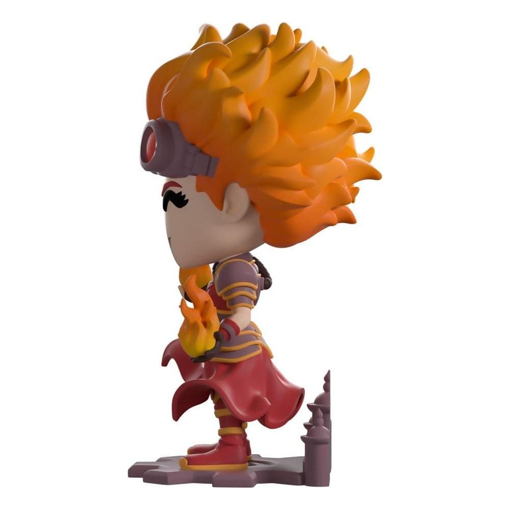 Eine stilisierte Figur mit orangefarbenem Haar, Goggles und rotem Kleid, die Feuer in der Hand hält.
