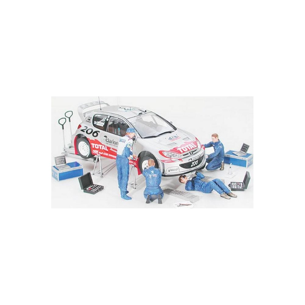 Mécaniciens miniatures travaillant sur une voiture de rallye avec 