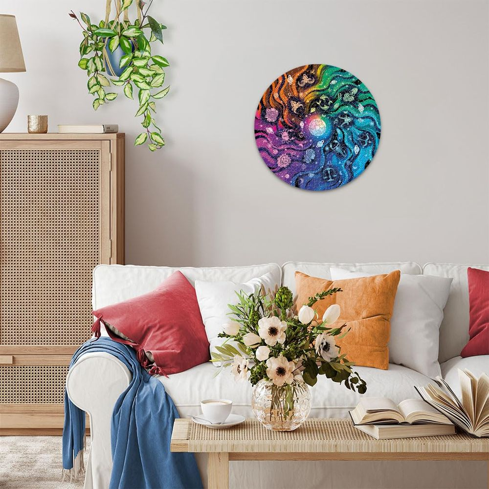 Ein kreisförmiges Wandbild mit Regenbogenfarben und Wirbelmustern hängt über einem Sofa.