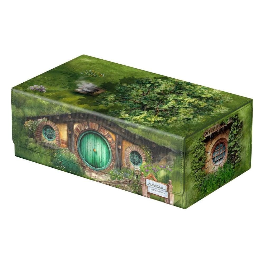 Une porte verte ronde sur une maison de hobbit avec des fenêtres rondes, couverte d'herbe.