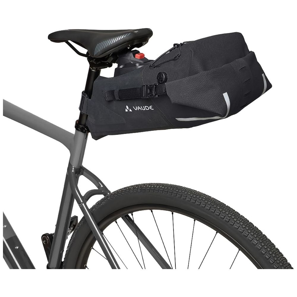 Une sacoche de selle VAUDE noire est fixée à la tige de selle d'un vélo gris.