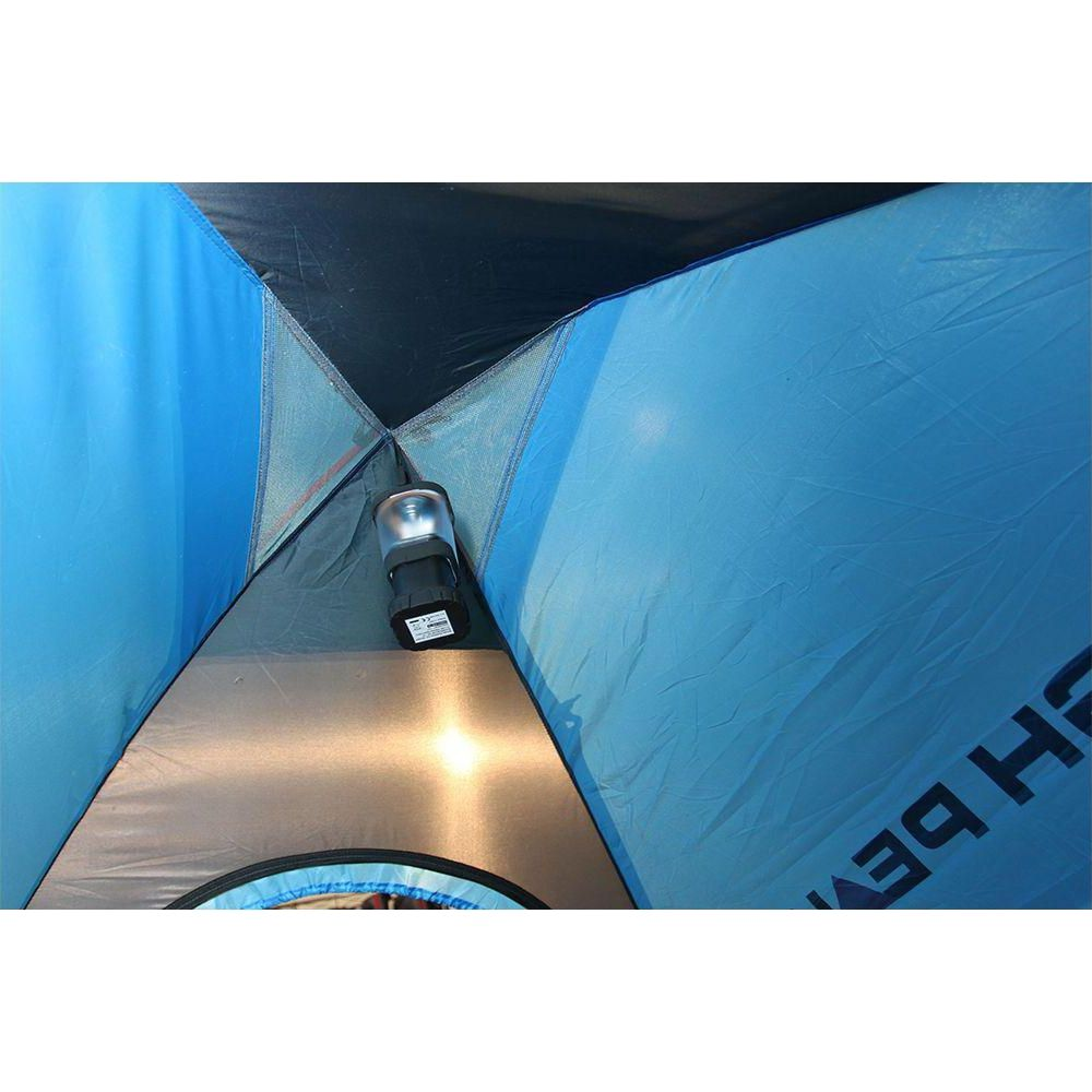 All'interno di una tenda blu, una lanterna a batteria illumina il pavimento.