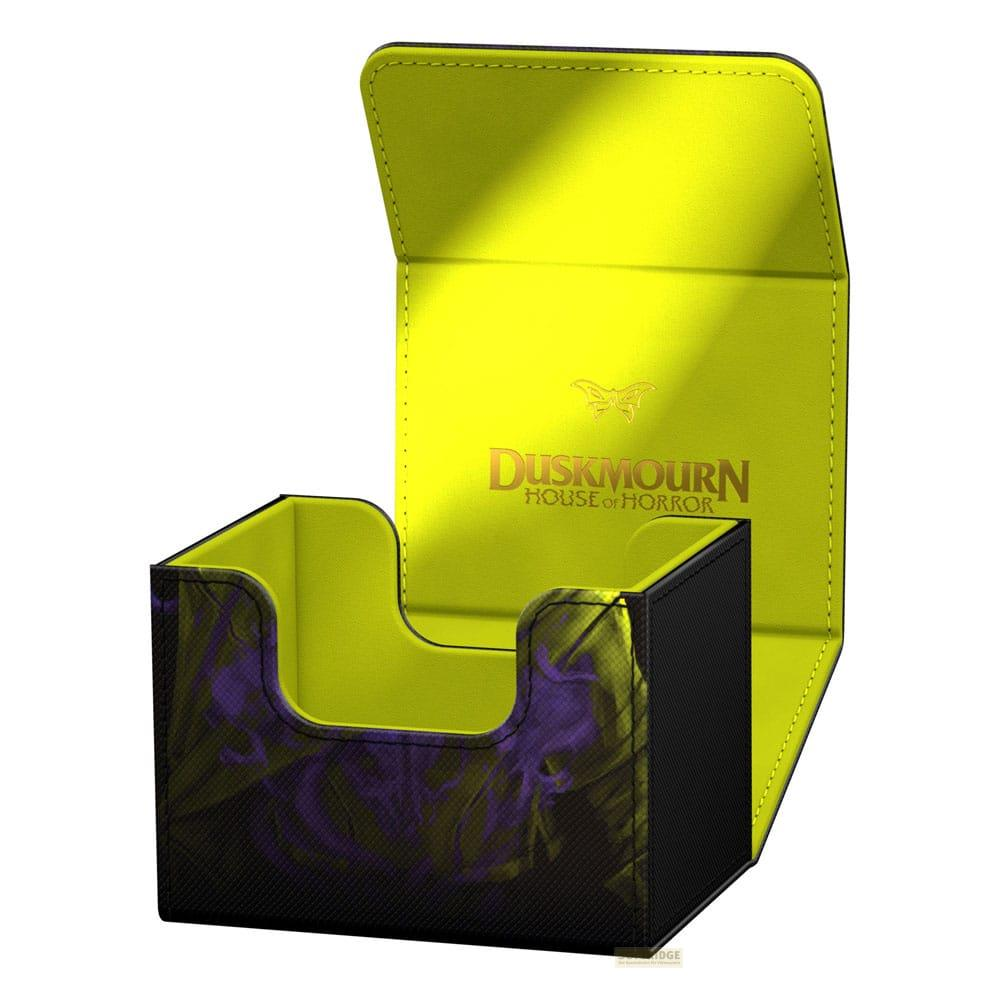 Une boîte de deck de cartes noire ouverte avec intérieur jaune arborant le logo Duskmoorn.