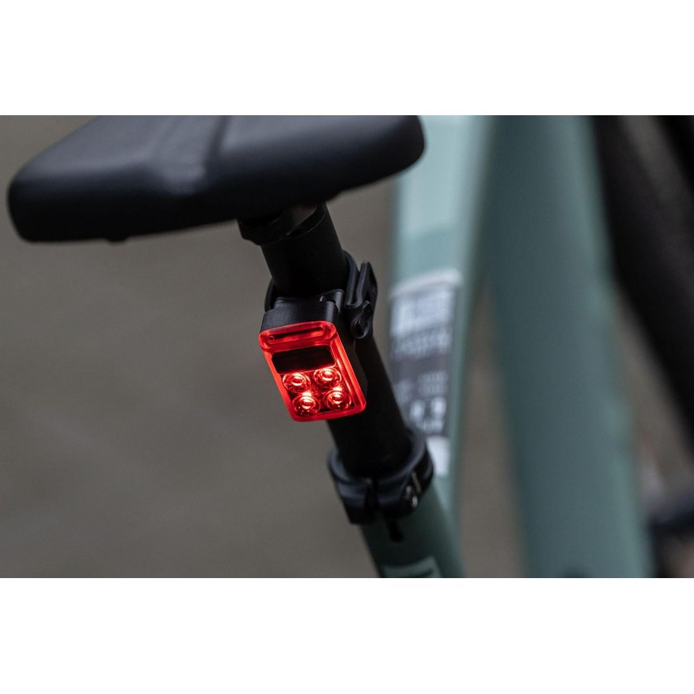Ein rotes Rücklicht mit vier LEDs ist an der Sattelstütze eines Fahrrads befestigt.