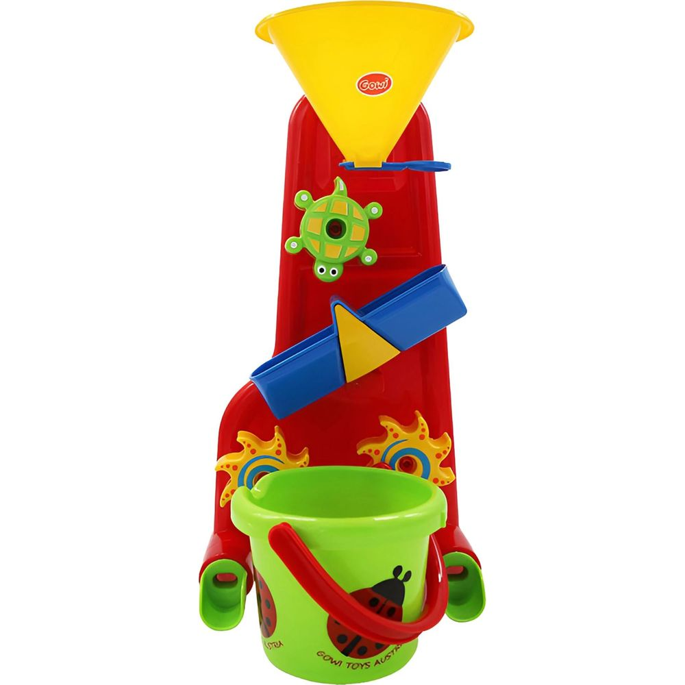 Ein rotes Spielzeug für den Sandkasten mit gelbem Trichter, grüner Eimer und Schildkröte.
