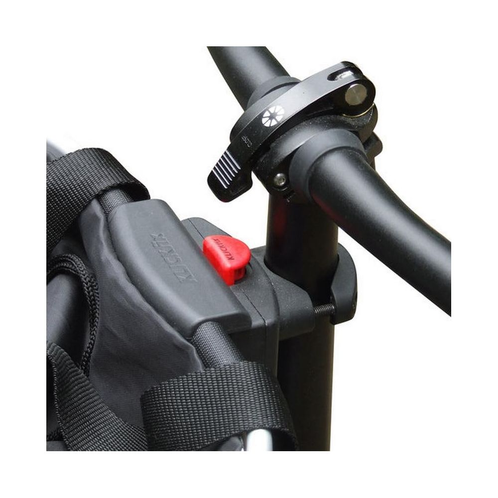 Nahaufnahme eines Fahrradlenkers mit schwarzer Tasche und rotem Knopf.