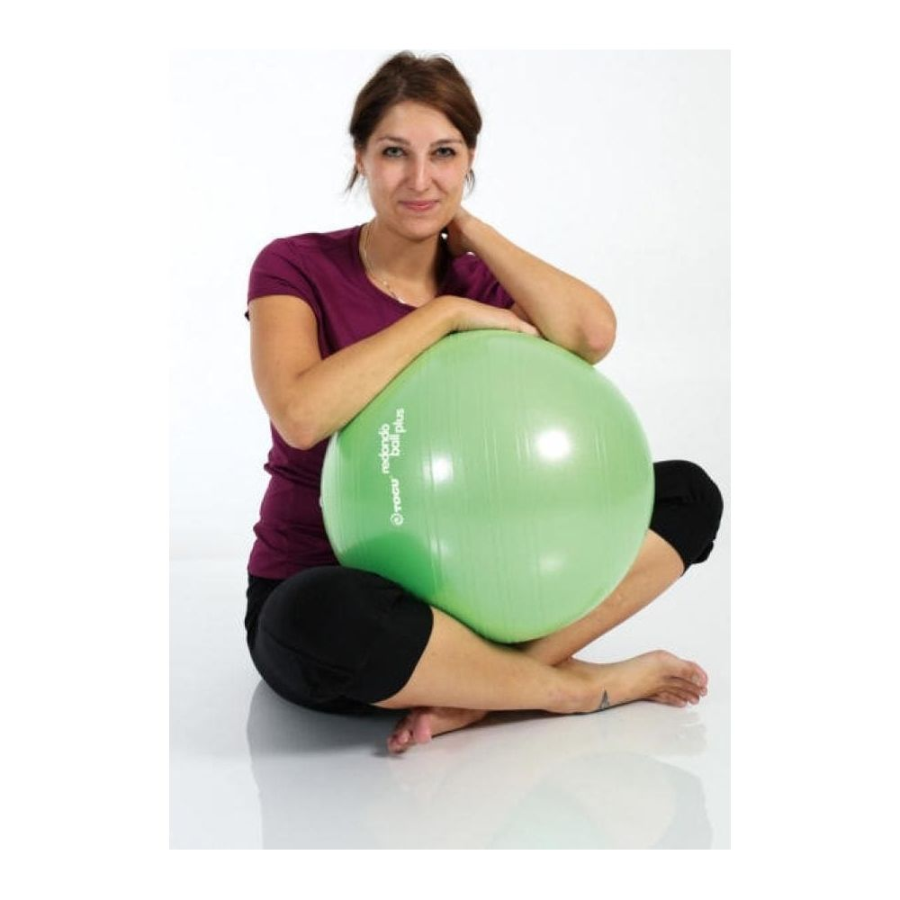 Eine Frau sitzt mit einem hellgrünen Gymnastikball auf dem Schoß.