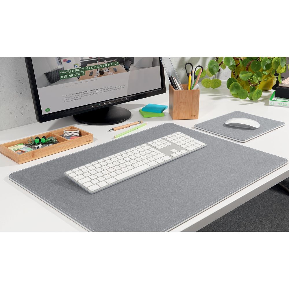 Un bureau moderne avec tapis de souris gris, clavier, souris et écran.