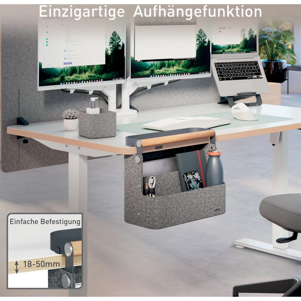 Schreibtisch mit zwei Monitoren, Laptop, Maus, Tastatur und hängender Aufbewahrungstasche.