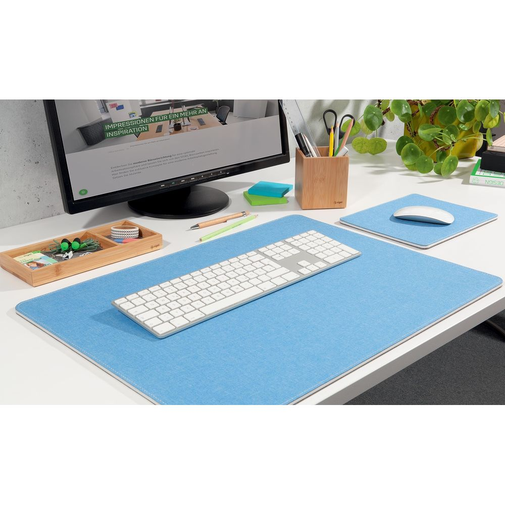 Una scrivania con tappetino blu, tastiera, mouse, monitor e cancelleria.
