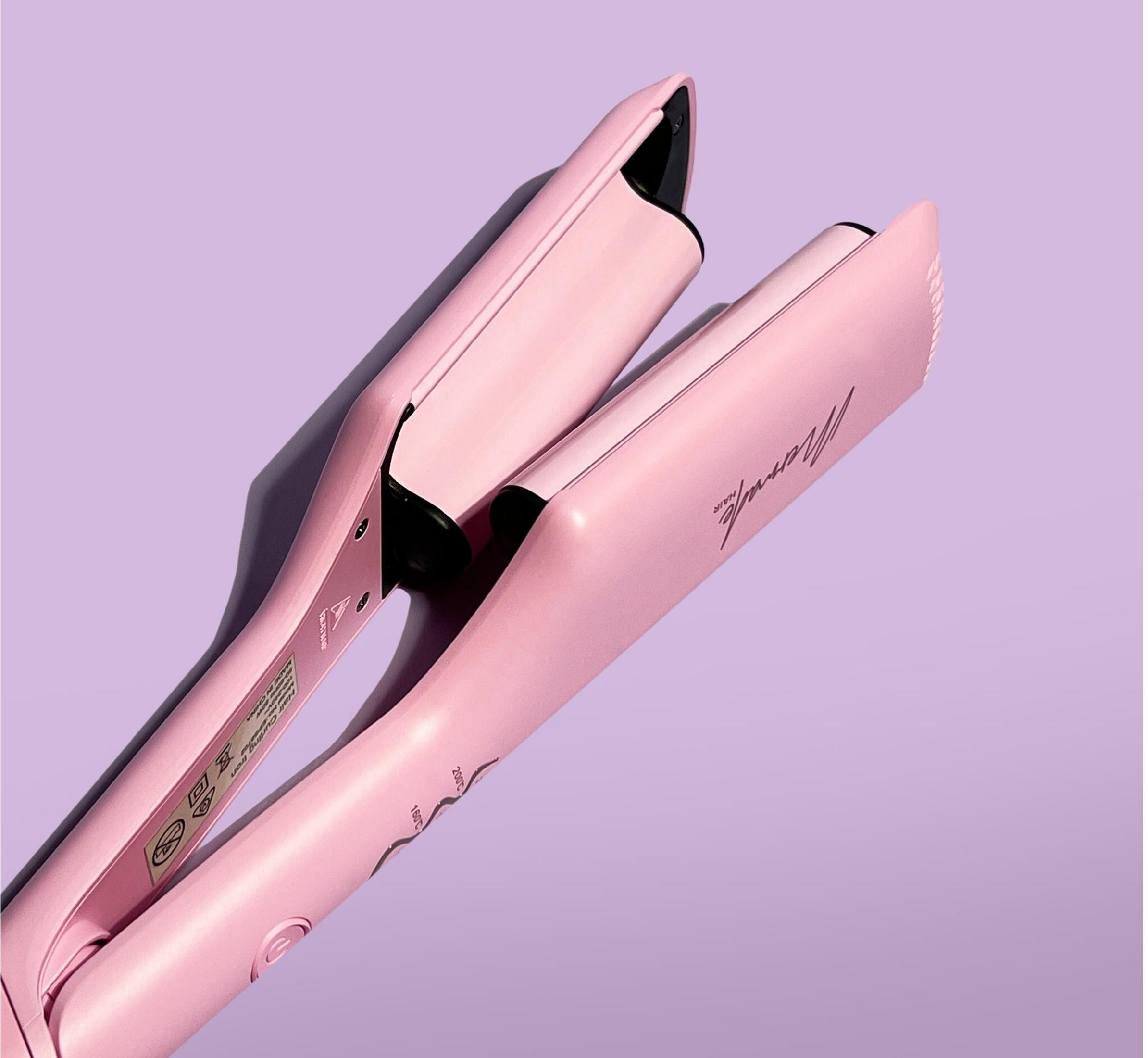 Ein pinker Glätteisen mit einer geschwungenen Form auf lavendelfarbenem Hintergrund.