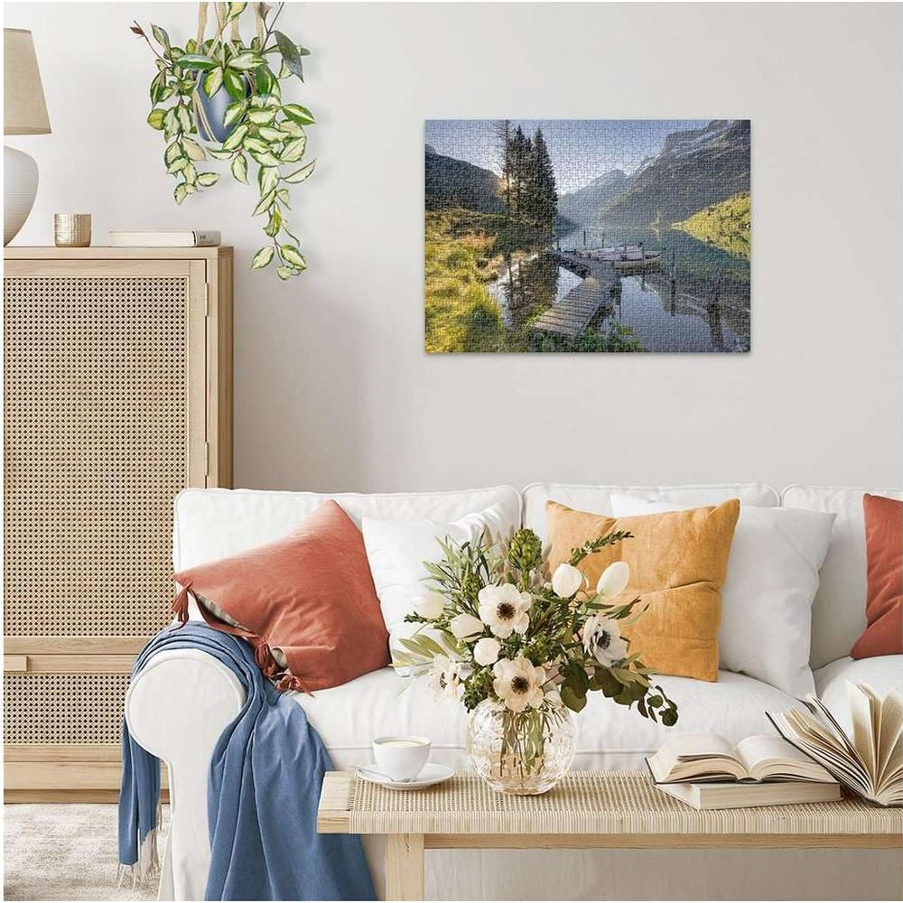 Puzzle d'un lac avec un quai et des montagnes, exposé au-dessus d'un canapé.
