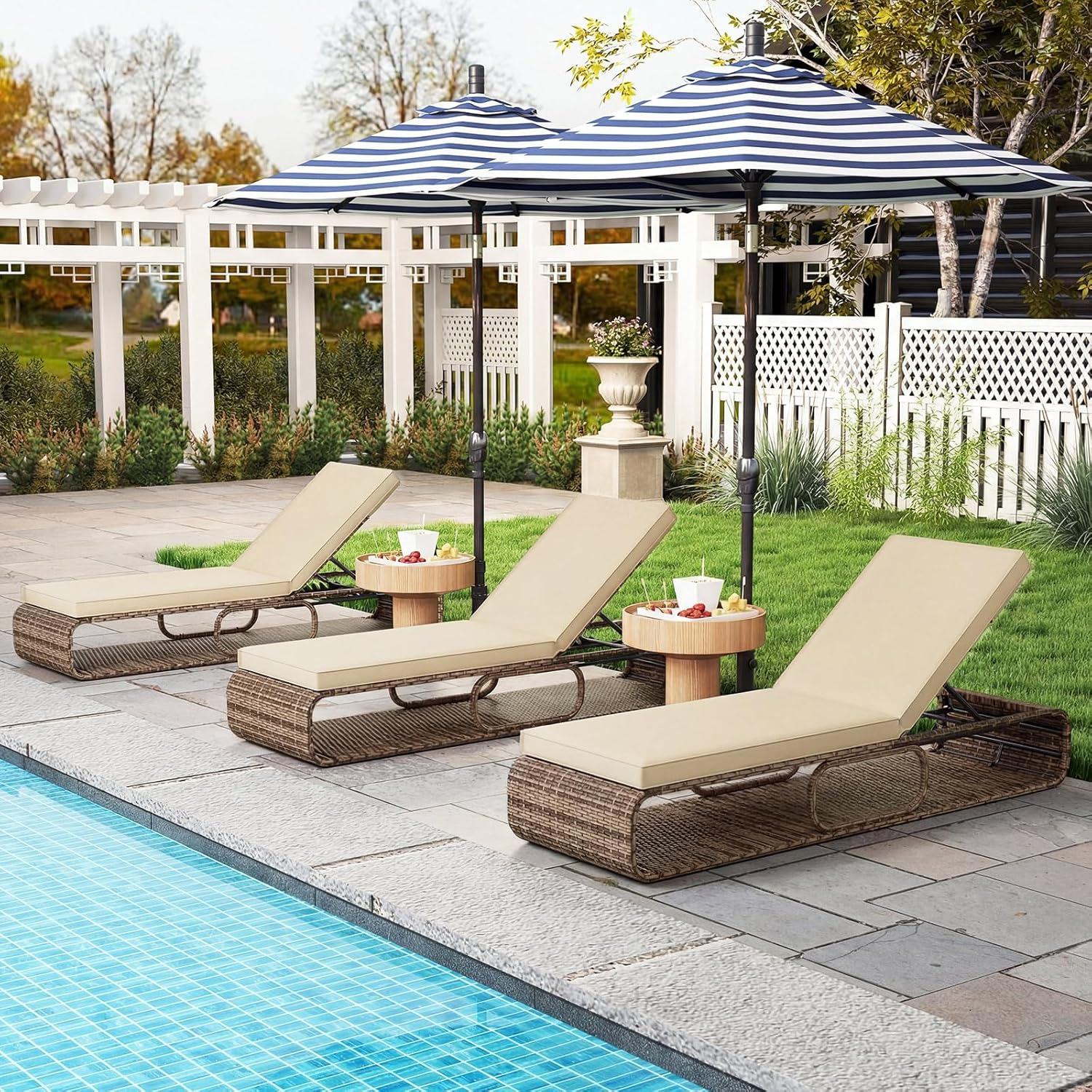 Drei Liegestühle mit beigefarbenen Kissen stehen neben einem Pool, beschirmt von blauen und weißen Sonnenschirmen.