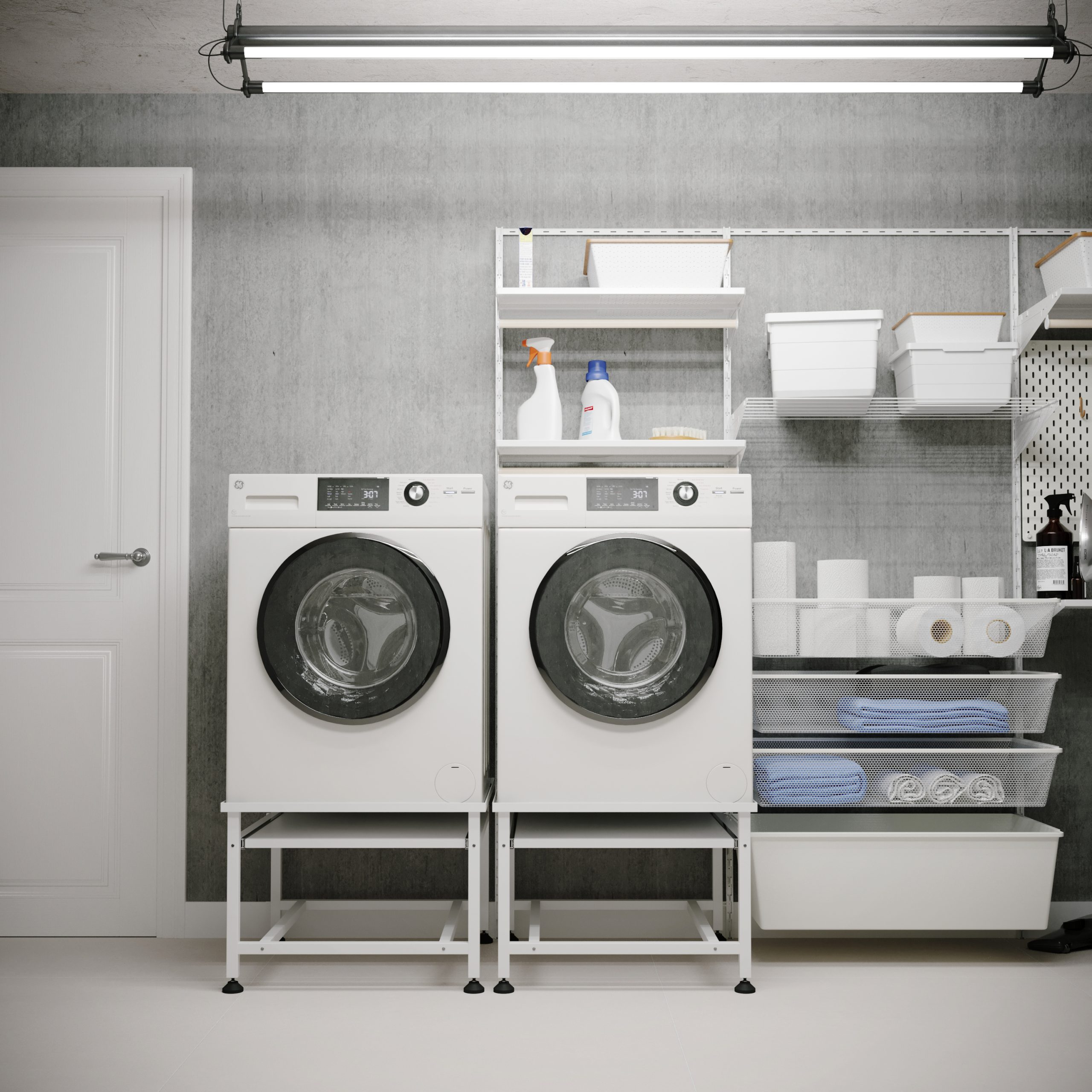 Two white washing machines stand side-by-side against concrete walls. Shelves hold laundry and toilet paper.