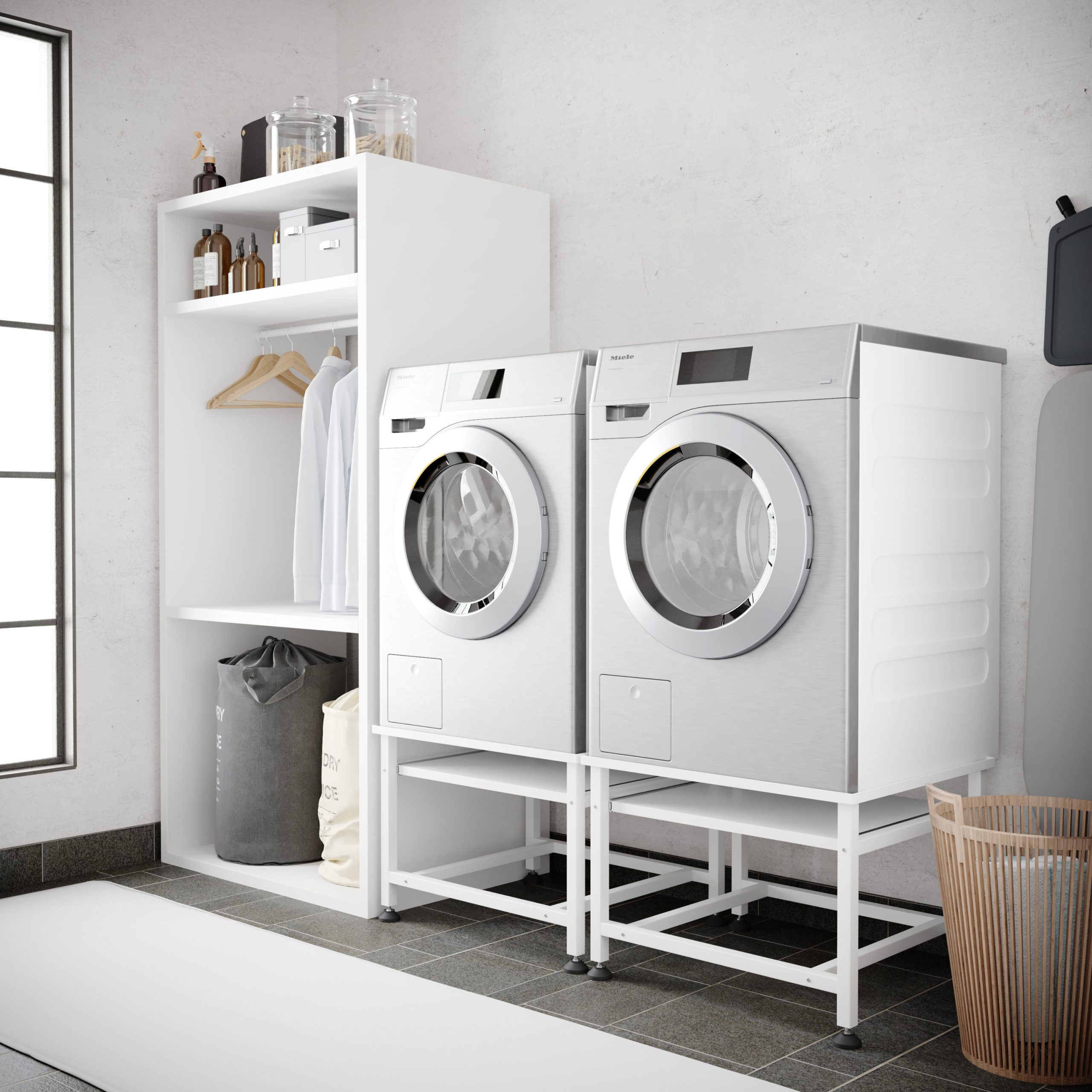 Two white washing machines on white stands, next to a shelf with laundry baskets.