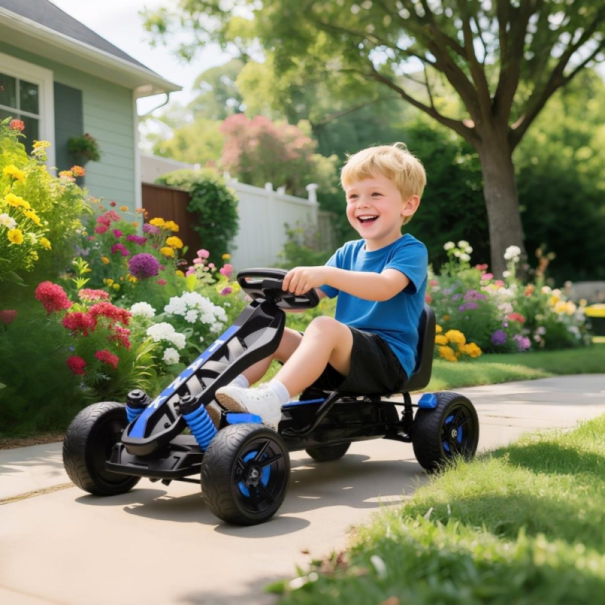 Ein Junge fährt ein blaues Go-Kart auf einem Gehweg neben einem Haus und Blumen.