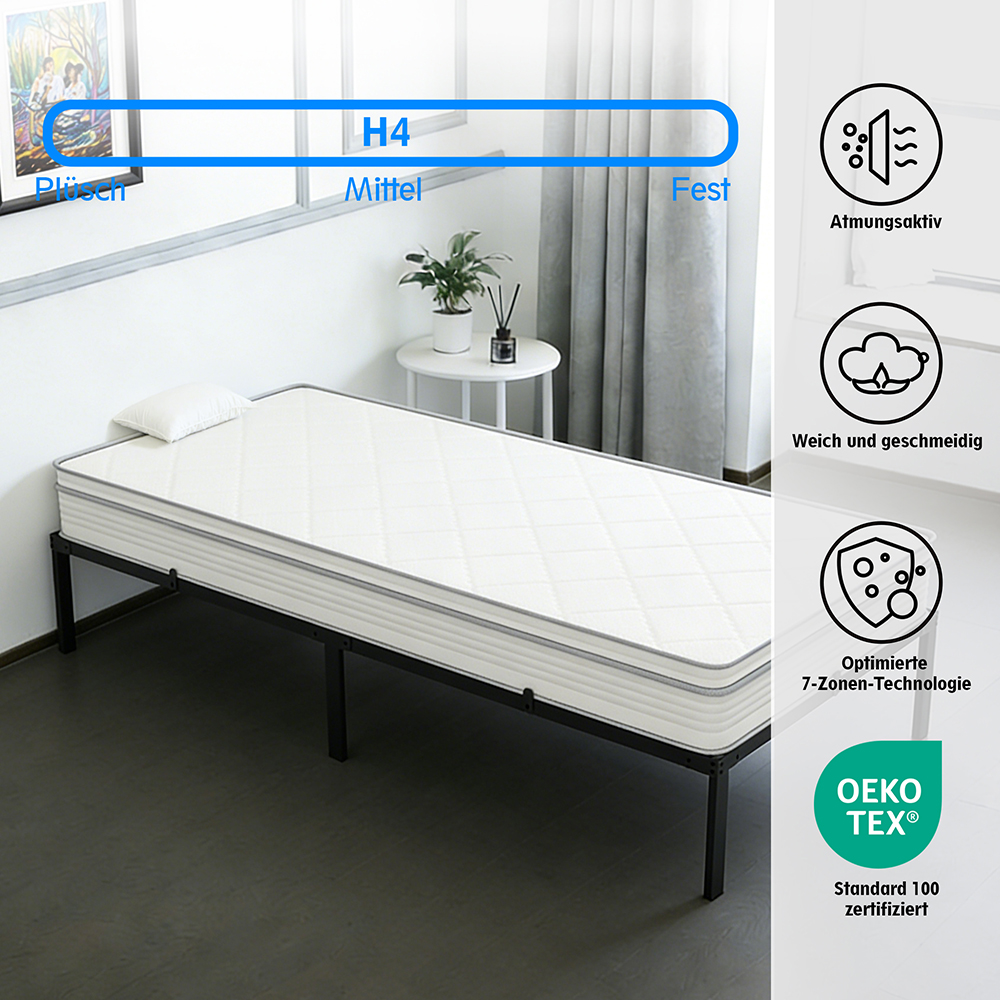 Ein weißes Bett mit einer Matratze, die auf einem schwarzen Metallrahmen liegt.