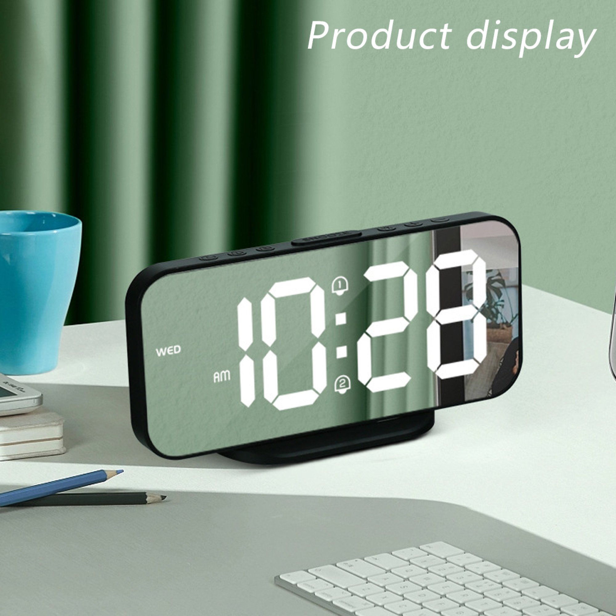 Digitaler Wecker zeigt 10:28 Uhr. Blaue Tasse, Tastatur und Bleistifte daneben.