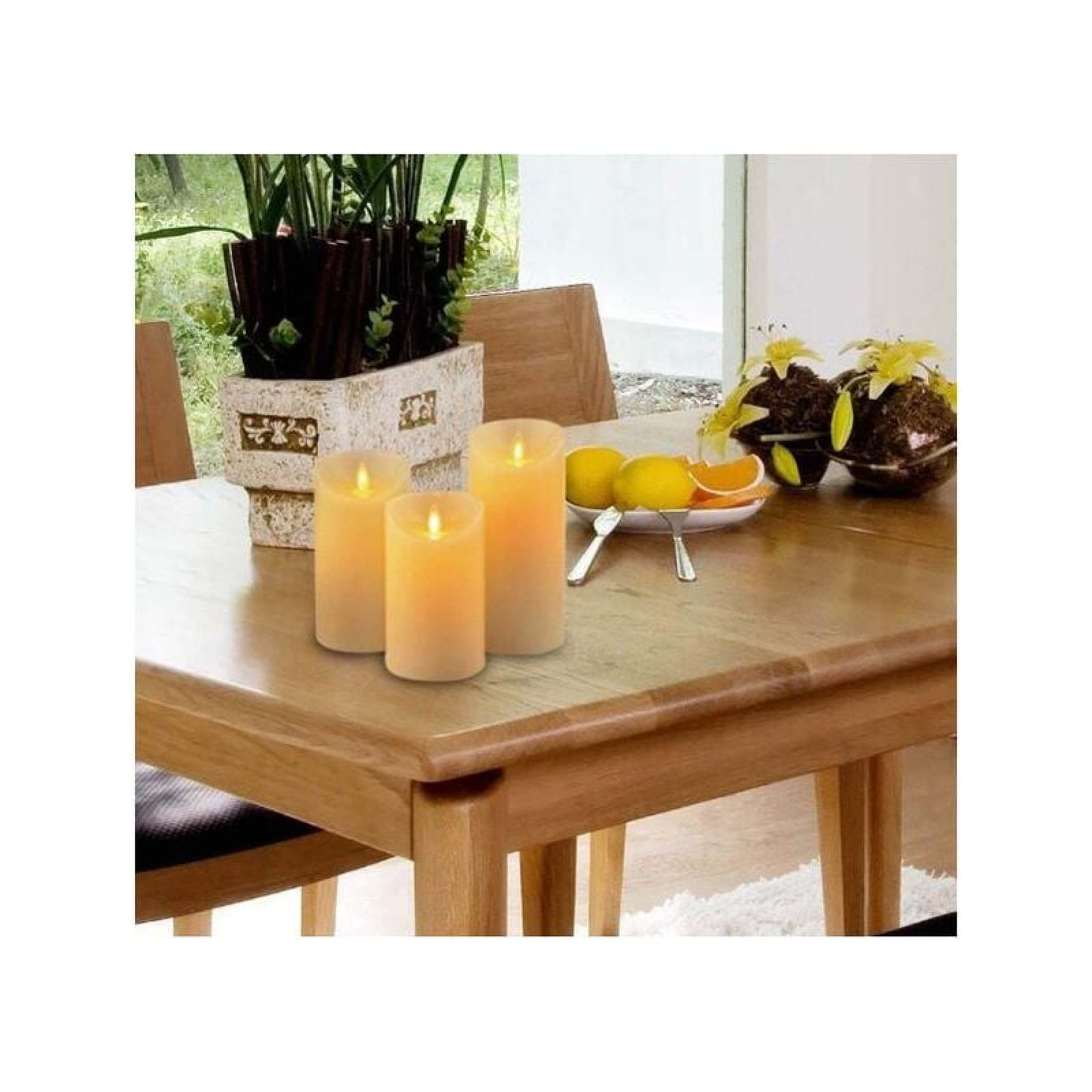 Drei LED-Kerzen auf einem Holztisch neben Orangen und Pflanzen.