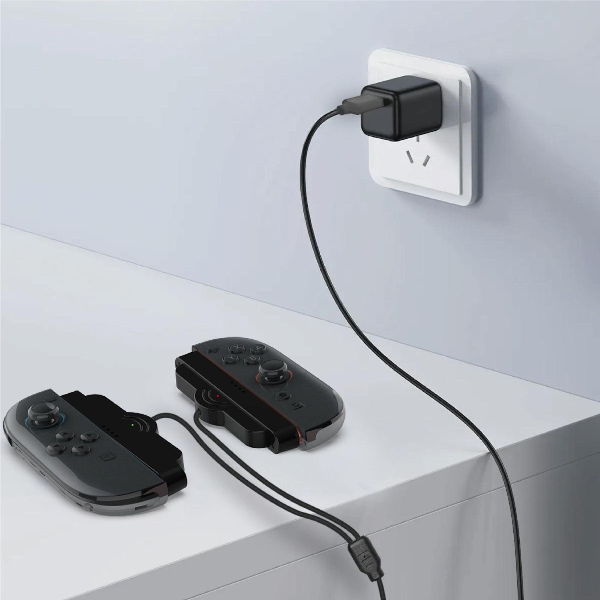 Zwei schwarze Controller werden an einer Steckdose mit einem schwarzen Ladegerät aufgeladen.